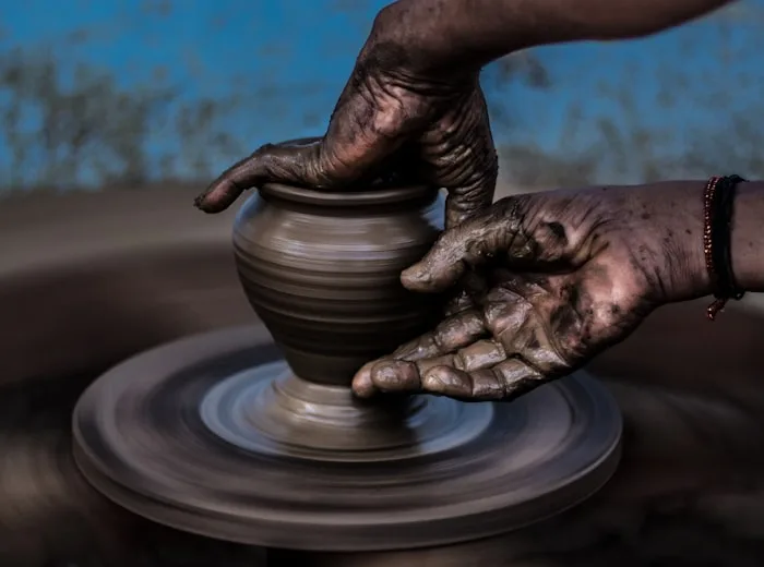 Potter shaping a handmade ceramic piece on a wheel